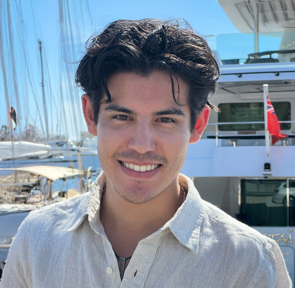 Christian Kai, founder of KAI Defense, beside a sailboat